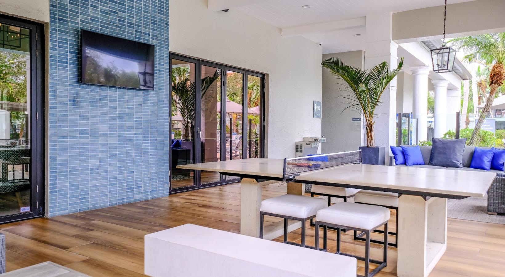 Quick access to state-of-the-art amenities a patio with a large blue wall and a large tv