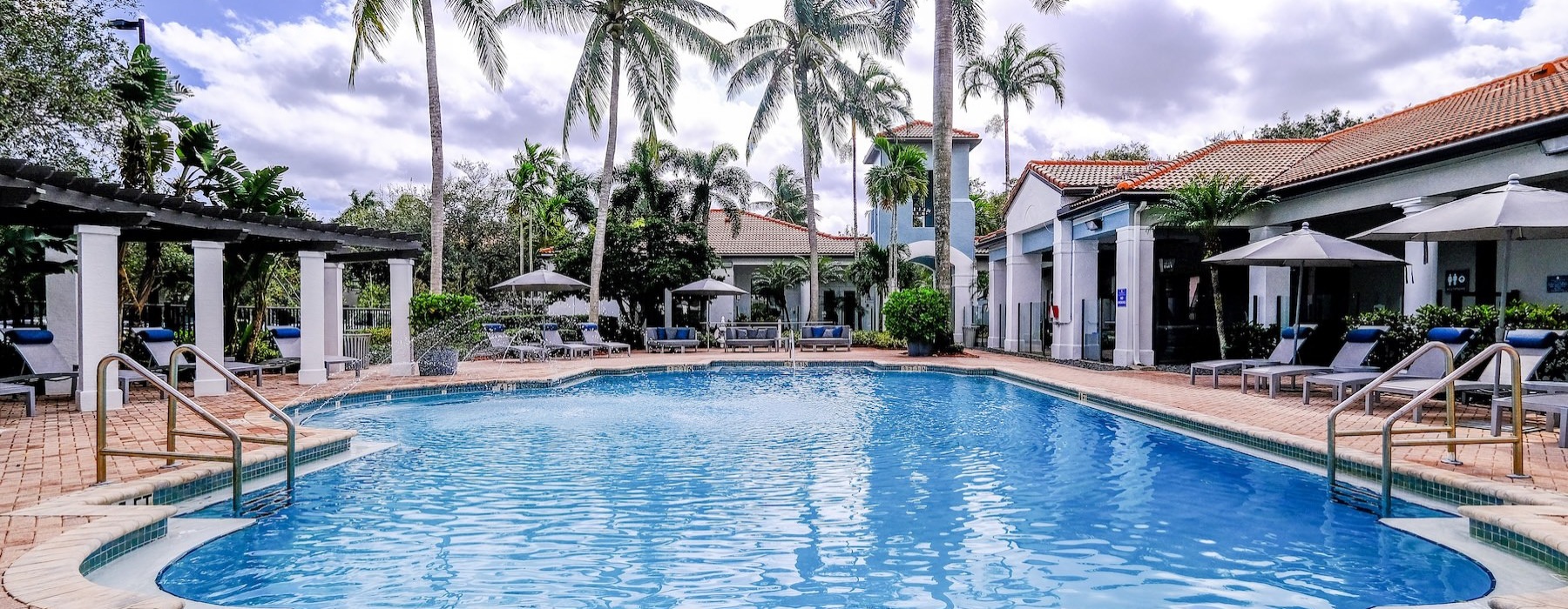 a pool with chairs and umbrellas by it