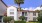 a large white building with a palm tree in front of it