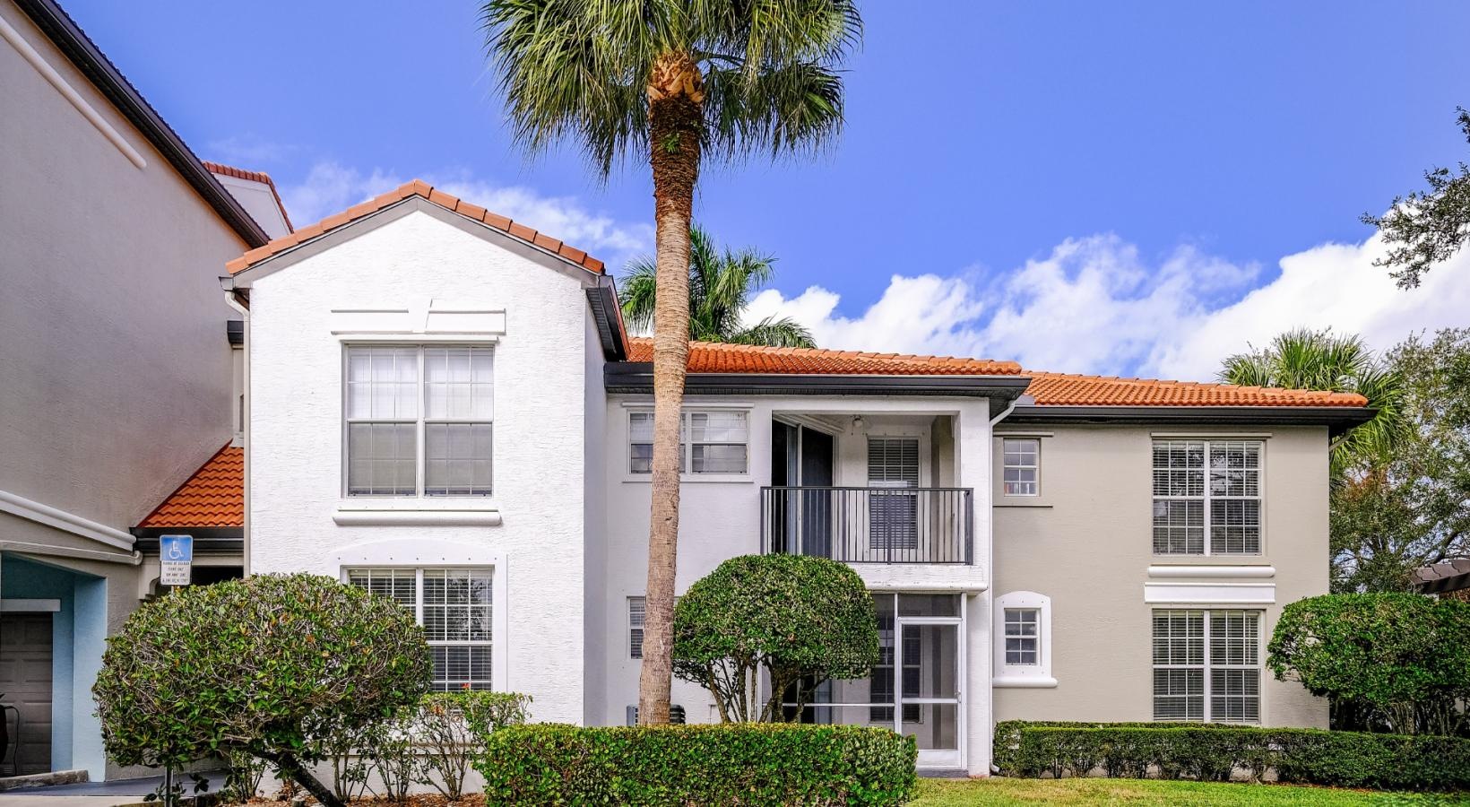 Settle into comfort at The Sophia at Abacoa a large white building with a palm tree in front of it