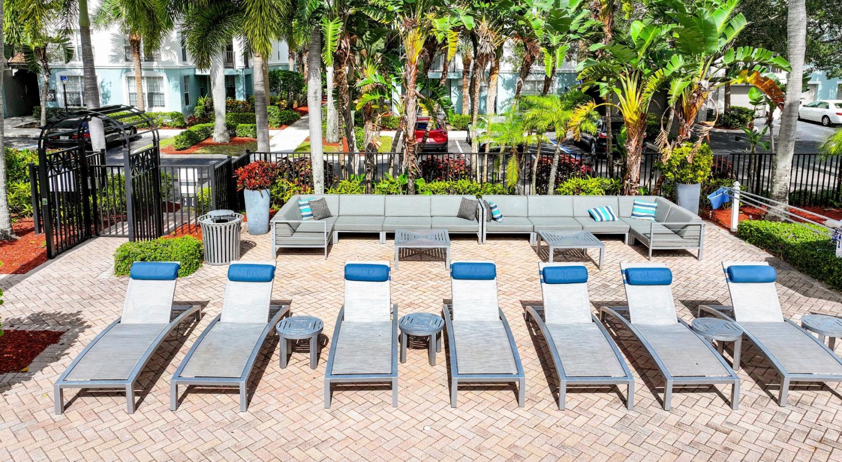 Relax and unwind poolside a group of chairs and tables outside in front of a pool
