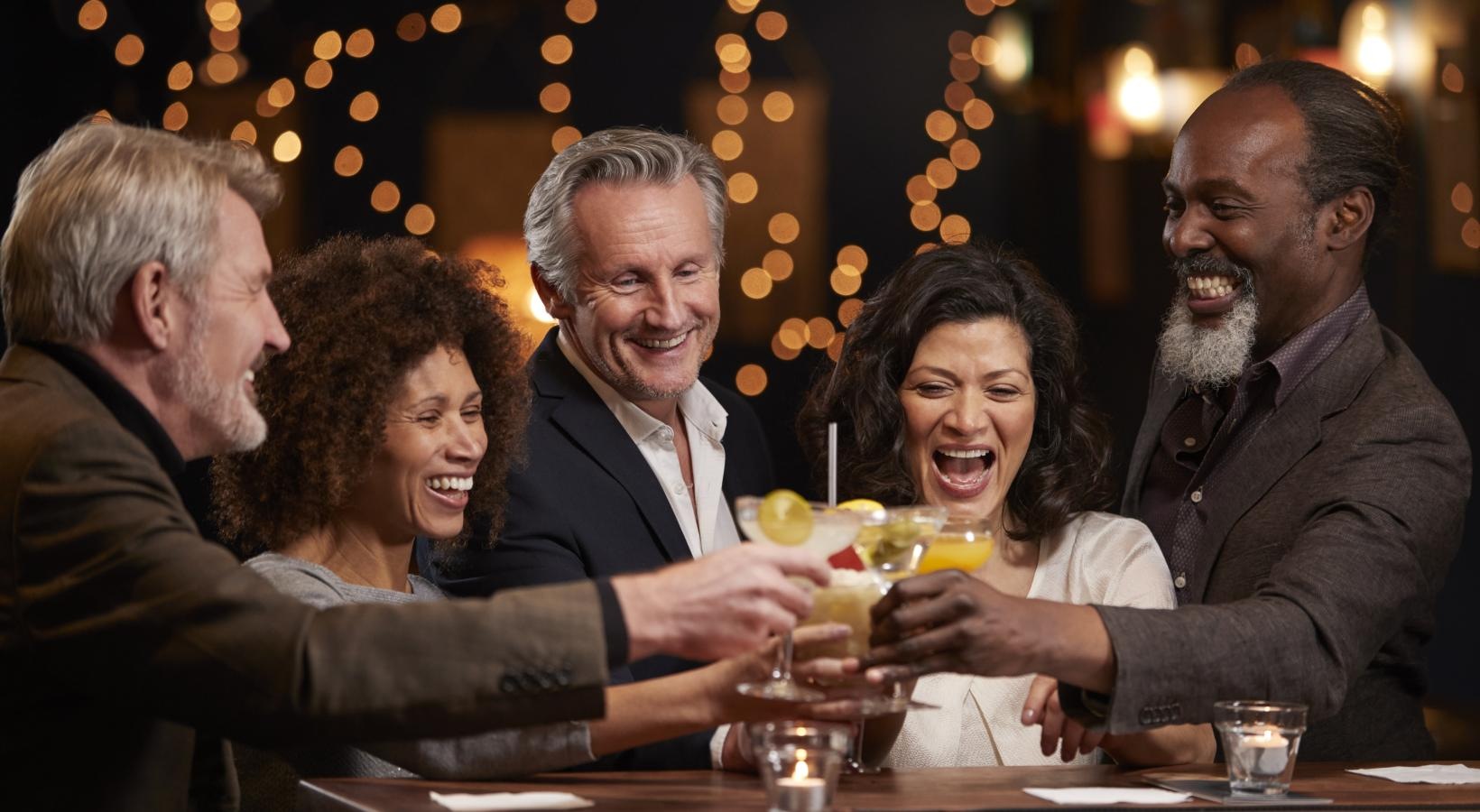 Close to the center of everything a group of people sitting at a table with drinks