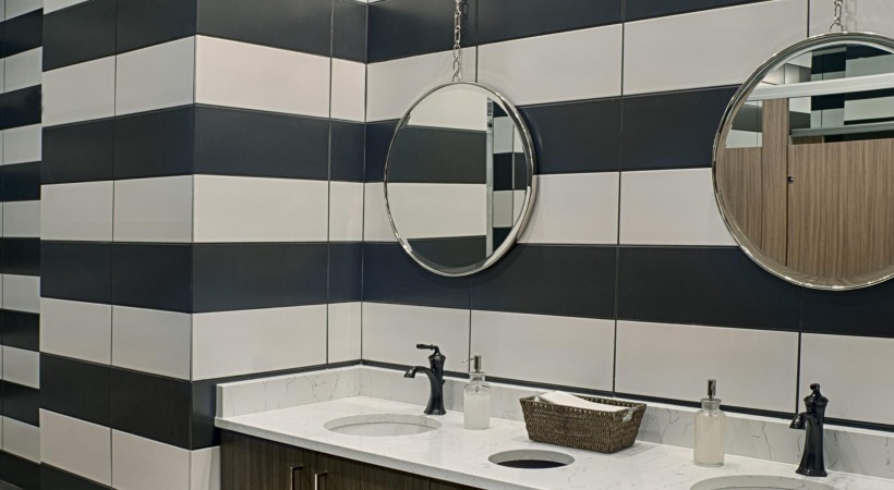 a clubhouse bathroom with a mirror and sinks