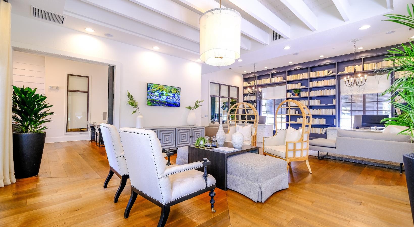 Cutting-edge amenities at your fingertips a clubhouse room with a table and chairs