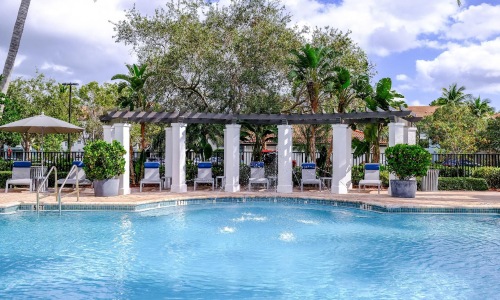 a pool with a gazebo and chairs by it
