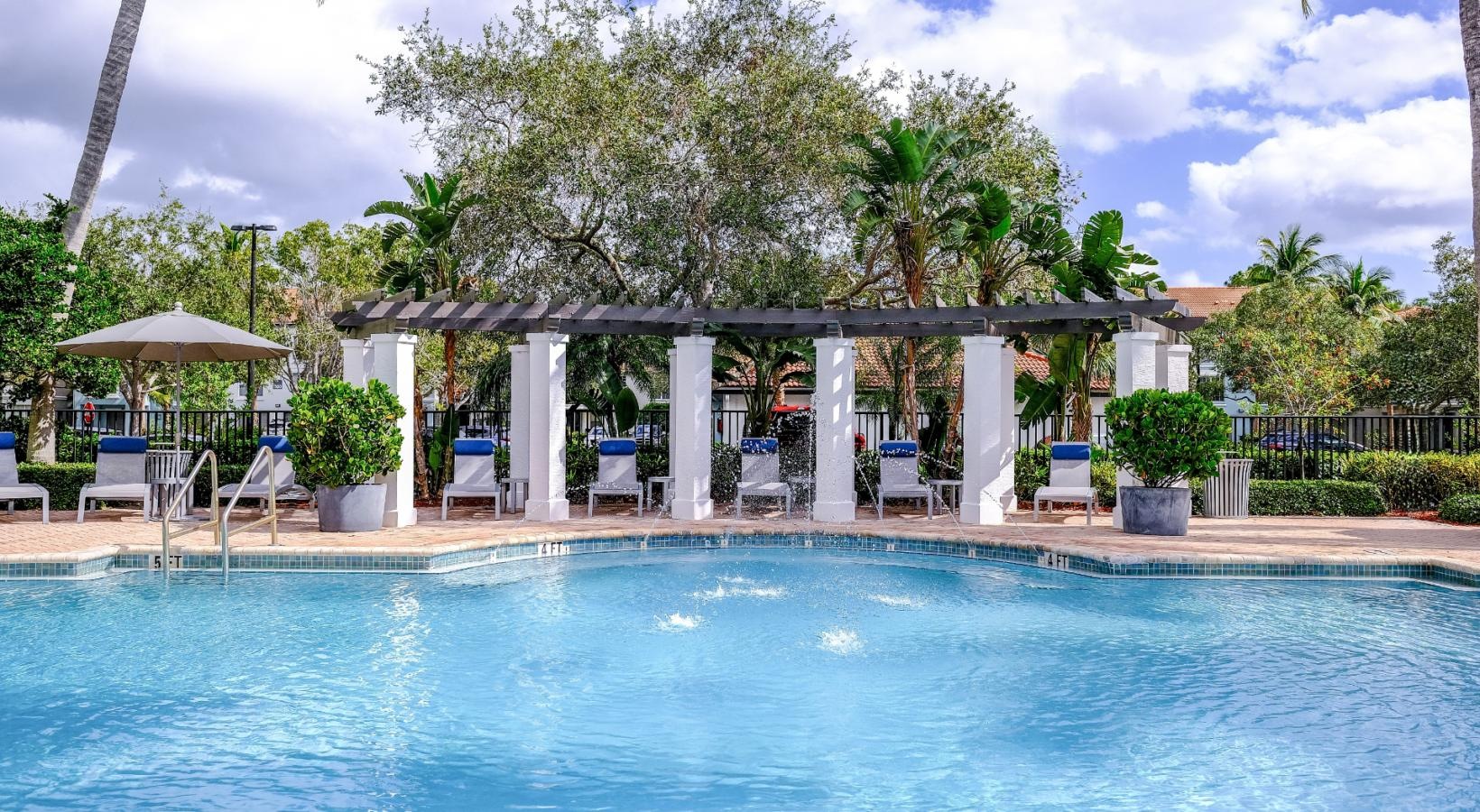 Shimmering resort-style pool a pool with a gazebo and chairs by it