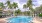 a pool with palm trees around it