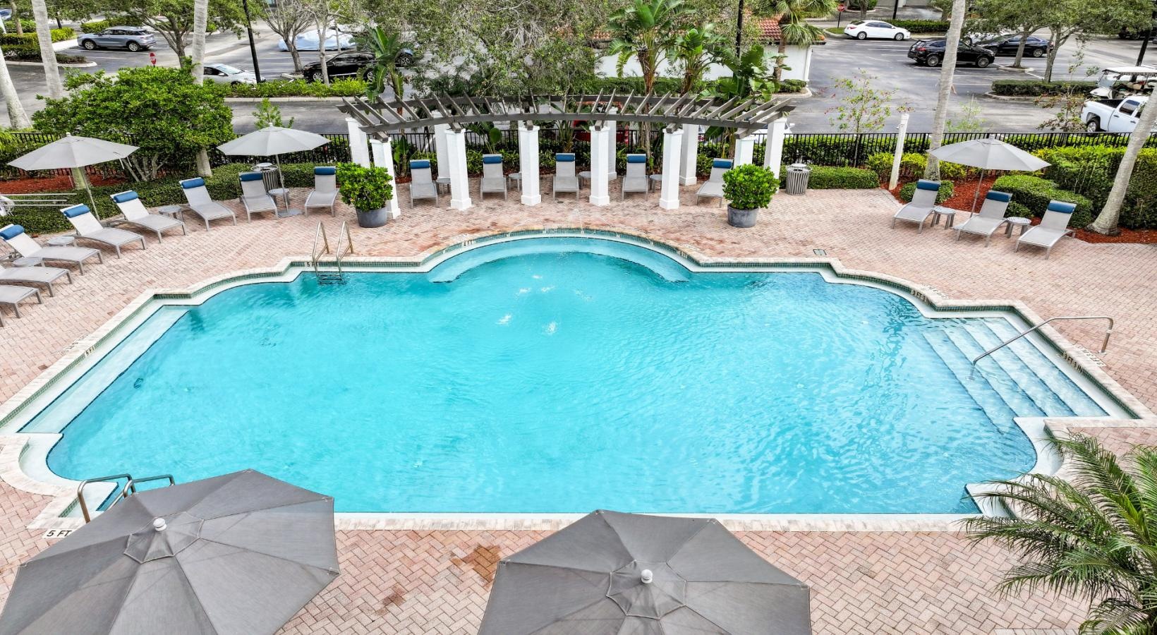 Shimmering resort-style pool a pool with chairs around it